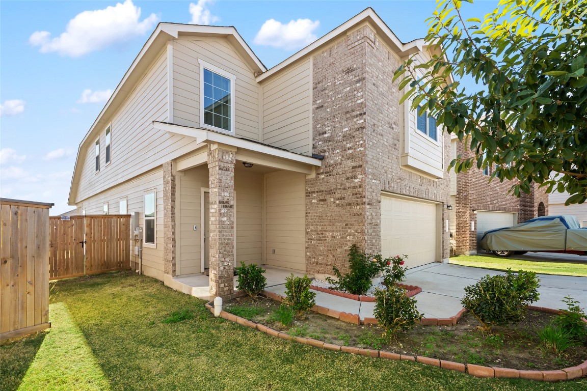 132 Joe Kidd Lane, Unit 132 Jarrell, TX 76537 - Photo 2 of 40 a view of a white house next to a yard with plants and trees