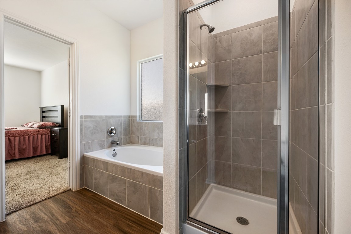 132 Joe Kidd Lane, Unit 132 Jarrell, TX 76537 - Photo 21 of 40 a bathroom with a tub a sink and a large mirror