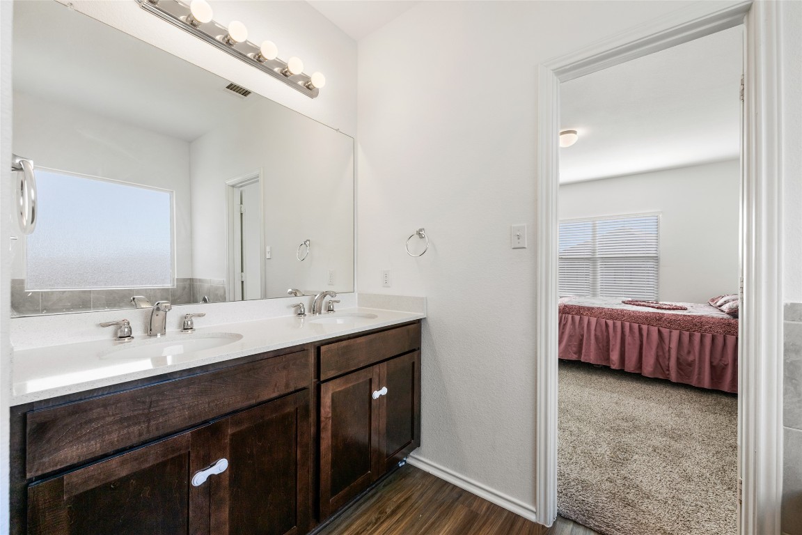132 Joe Kidd Lane, Unit 132 Jarrell, TX 76537 - Photo 22 of 40 a en suite bathroom with a double vanity sink and a mirror