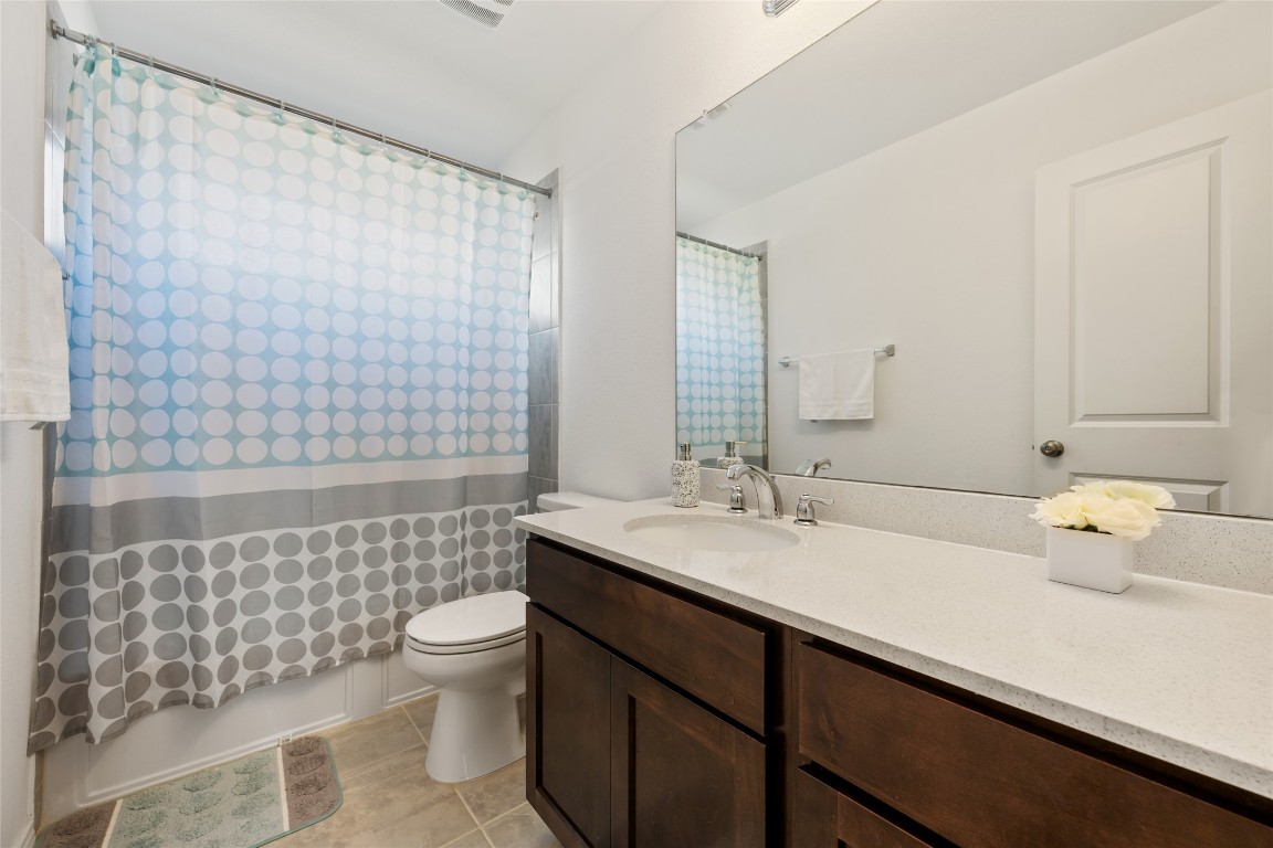 132 Joe Kidd Lane, Unit 132 Jarrell, TX 76537 - Photo 34 of 40 a bathroom with a sink a toilet and shower curtain