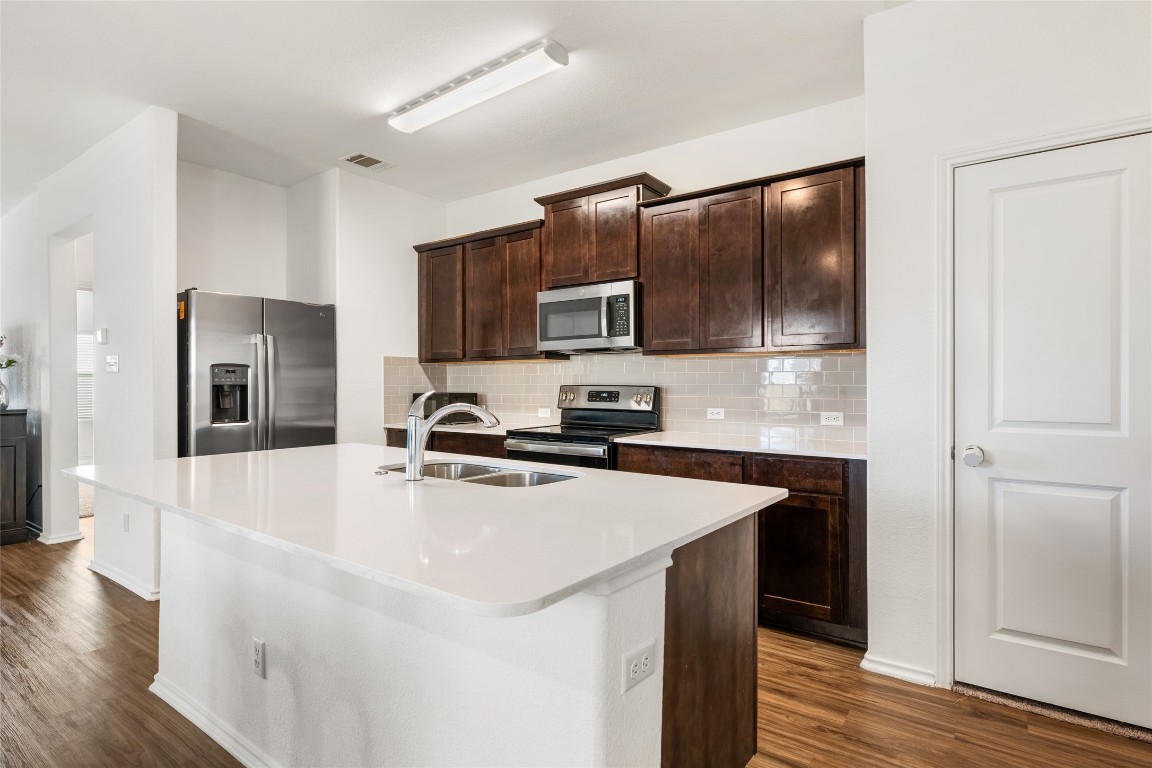 132 Joe Kidd Lane, Unit 132 Jarrell, TX 76537 - Photo 9 of 40 a kitchen with stainless steel appliances a refrigerator stove microwave and sink