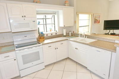 4772 Navigator Lane Boynton Beach, FL 33436 - Photo 9 of 44 a kitchen with white cabinets appliances and a window