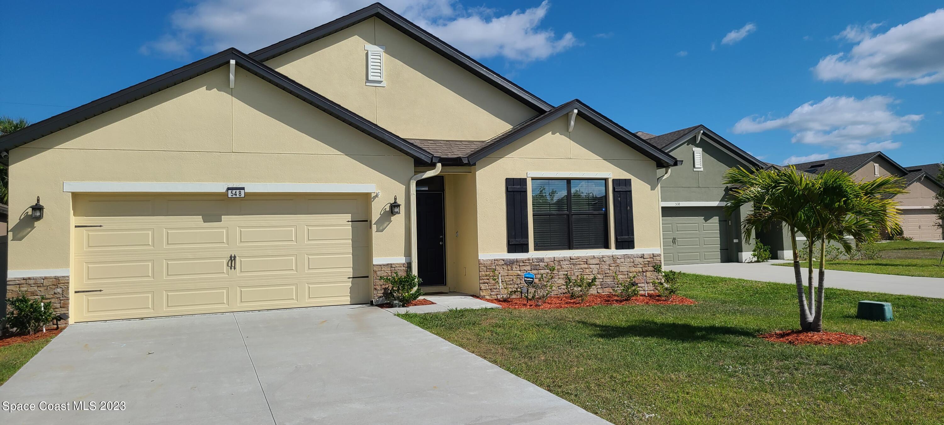 a front view of a house with a yard and garage