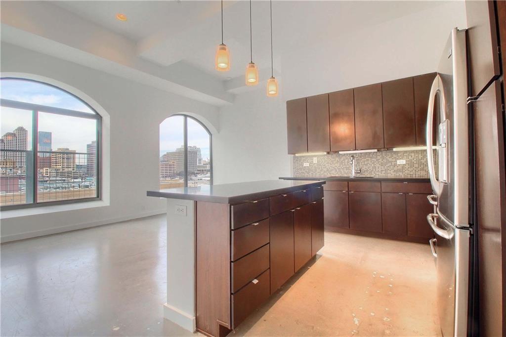 a kitchen with stainless steel appliances granite countertop a refrigerator a sink a stove and oven