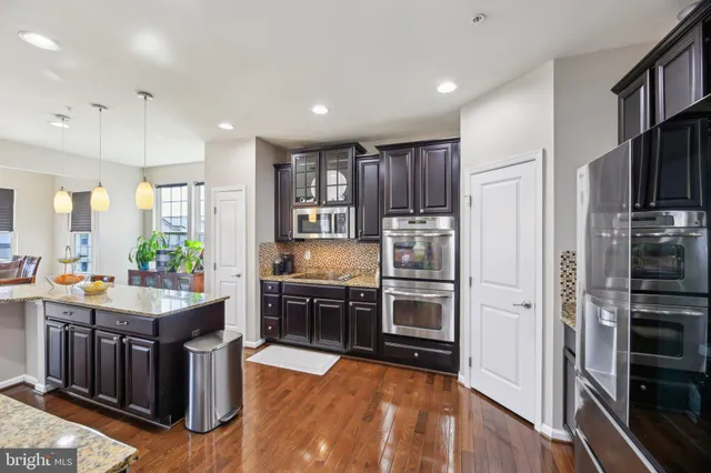 a kitchen with stainless steel appliances granite countertop sink stove and refrigerator