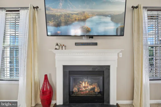 a living room with furniture kitchen view and a large window