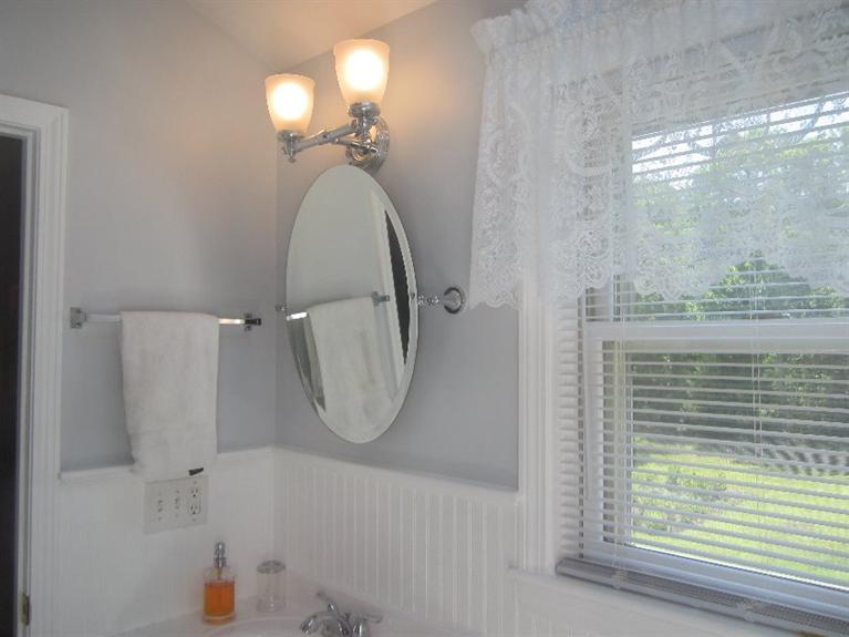 5 Cotuit Road Sandwich, MA 02563 - Photo 19 of 34 a bathroom with a mirror a bathtub and shower