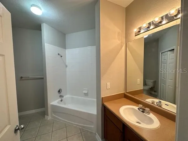 a bathroom with a tub sink and mirror
