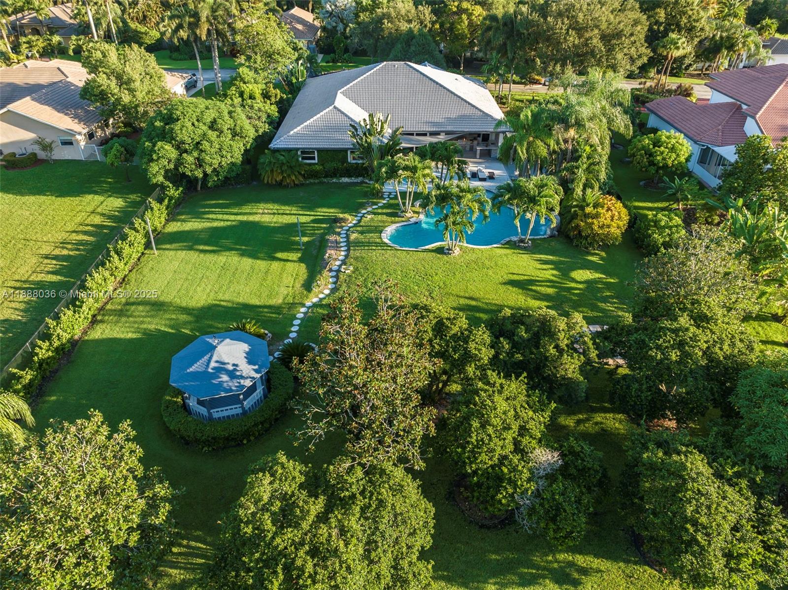 12555 Southwest 34th Place Davie, FL 33330 - Photo 32 of 73 a view of a garden with a table and chairs under an umbrella