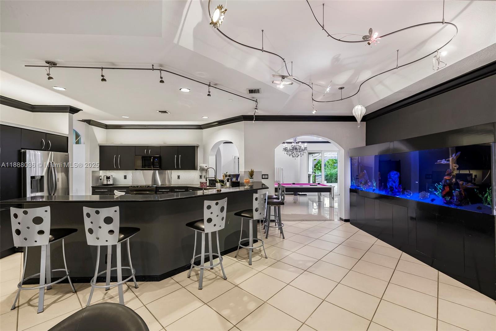 12555 Southwest 34th Place Davie, FL 33330 - Photo 51 of 73 a kitchen with stainless steel appliances kitchen island granite countertop a table chairs in it and a window