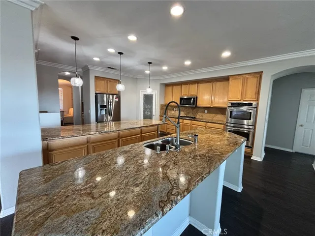 an empty room with wooden floor fireplace and windows