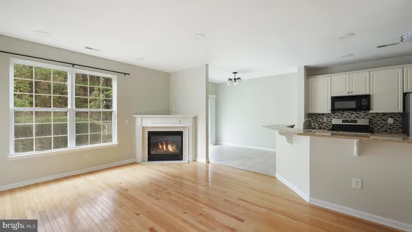 a view of an empty room with a window and fireplace