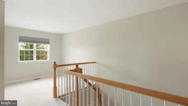 a view of staircase with white walls and a window