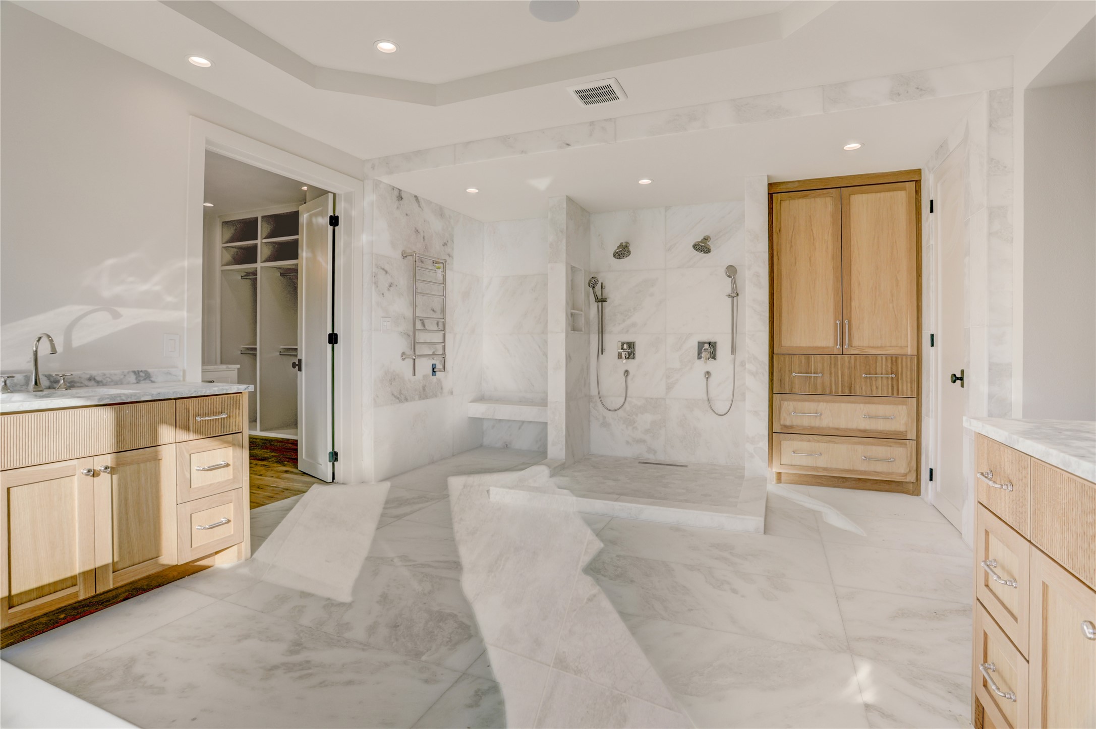 2250 Sunset Boulevard Houston, TX 77005 - Photo 23 of 40 Another view of the primary bath - large shower with dressing bench to the left and heated towel rack. To the right is towel storage and the water closet.