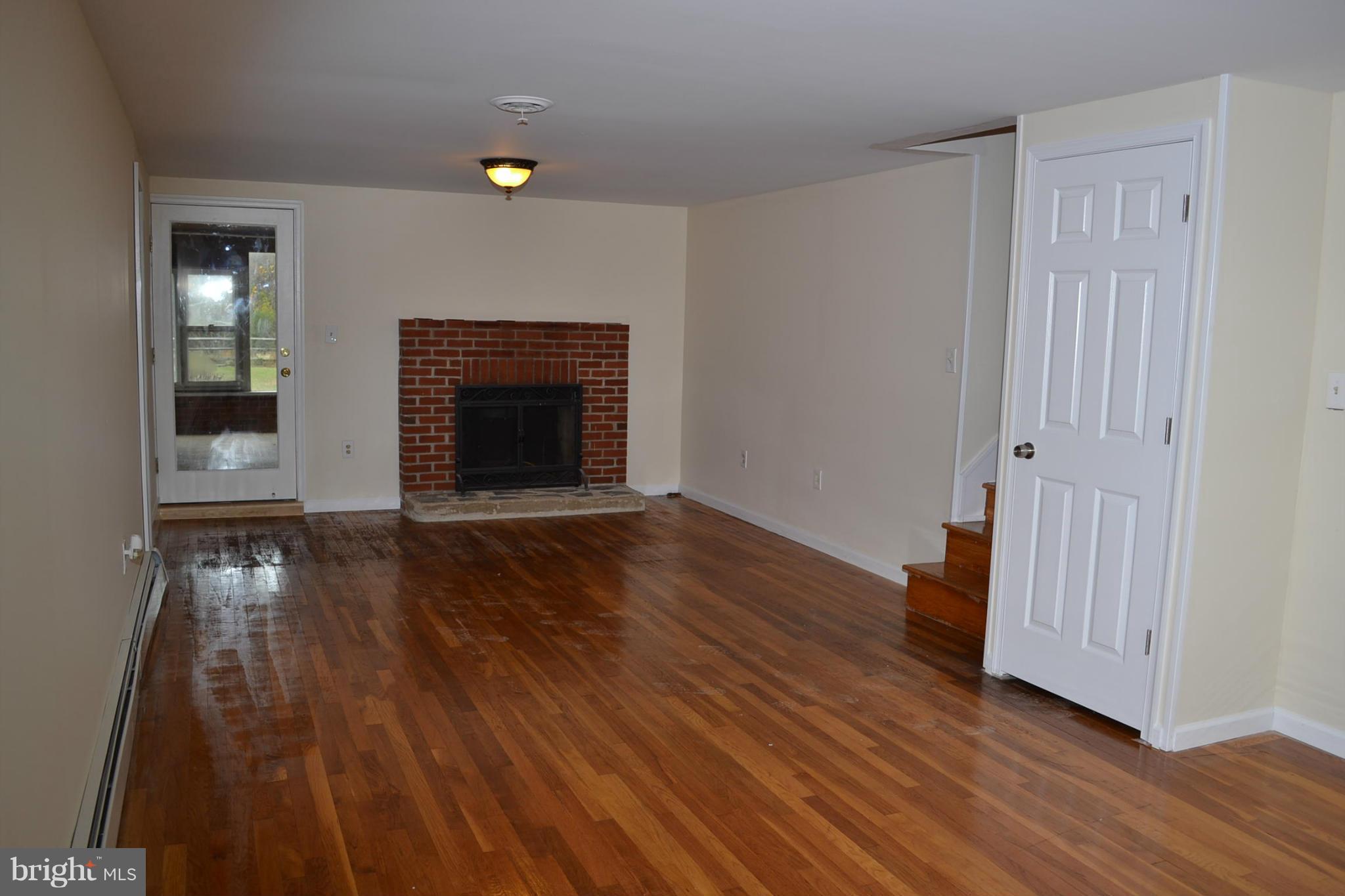 155 Brewster Bridge Road Elkton, MD 21921 - Photo 7 of 30 an empty room with wooden floor and fireplace