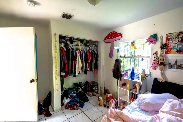 a view of walk in closet with clothes and shoes
