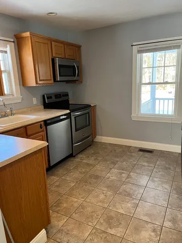 a kitchen with stainless steel appliances granite countertop a stove a sink and a microwave