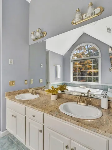 a bathroom with a granite countertop sink and a large mirror