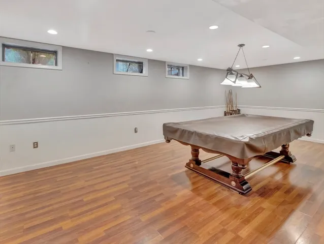 a room with wooden floor and pool table