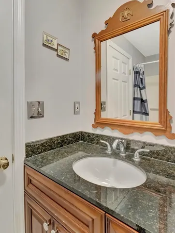 a bathroom with a granite countertop sink and a mirror