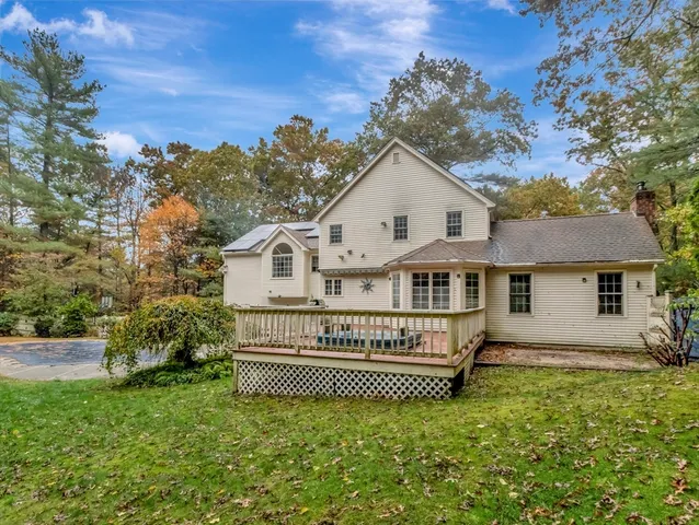 a view of a house with a wooden deck and a yard