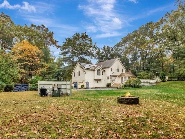 a view of a house with a yard and sitting area