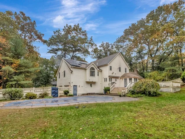 a view of a white house with a big yard and large trees