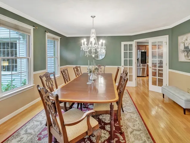 a view of a dining room with furniture a chandelier and wooden floor