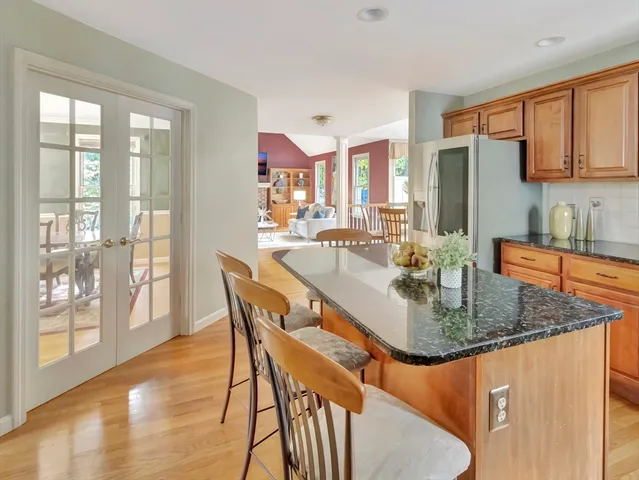 a dining room with furniture window wooden floor and kitchen view