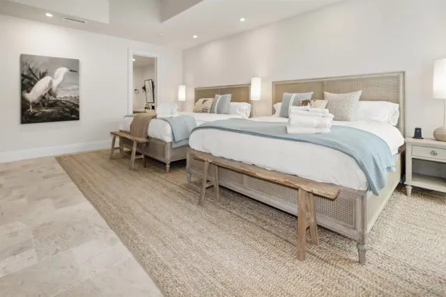 a spacious bedroom with a bed a ceiling fan and a rug