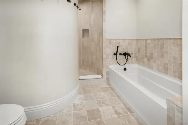 a spacious bedroom with a bed and a chandelier