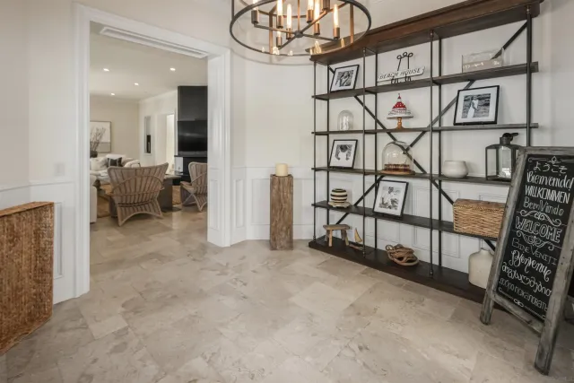 a kitchen that has a lot of white cabinets and stainless steel appliances