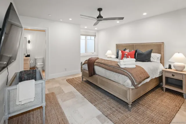 a spacious bedroom with a bed a table and chairs