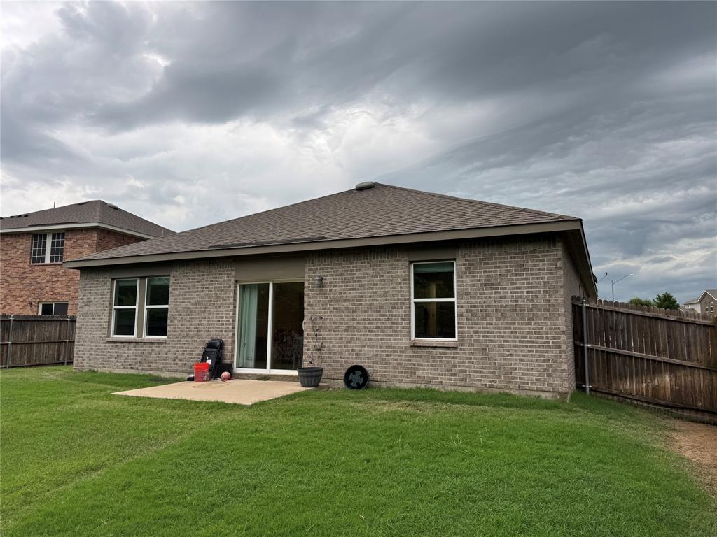 2209 Cinnamon Spgs Road Glenn Heights, TX 75154 - Photo 26 of 28 Expansive grassy backyard featuring a concrete patio, brick exterior, and a privacy fence