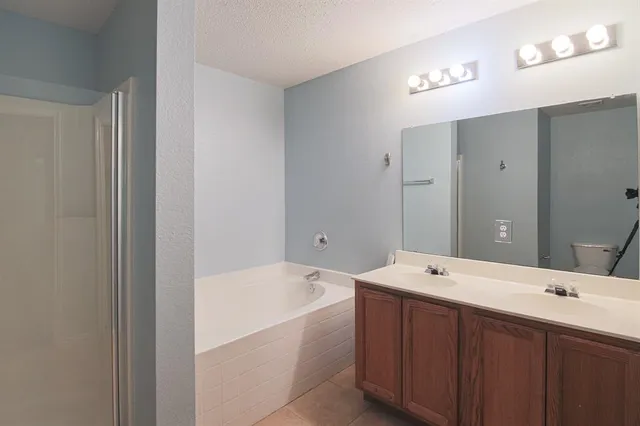 a bathroom with a tub a sink and mirror