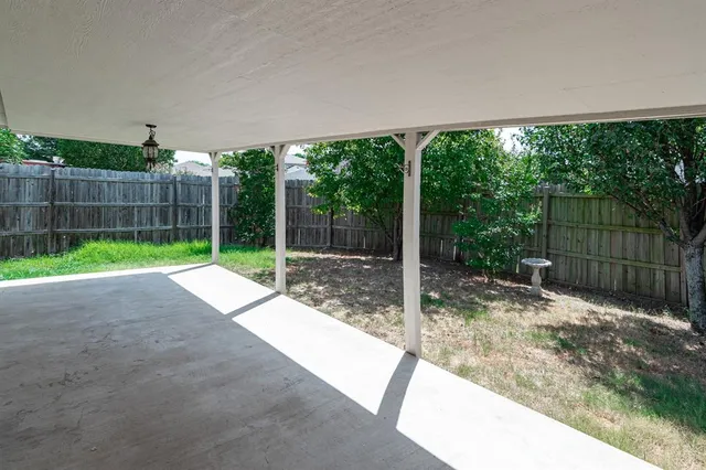 a backyard of a house with plants and wooden fence