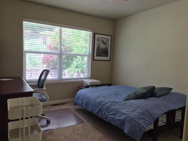 a bedroom with a bed window and desk