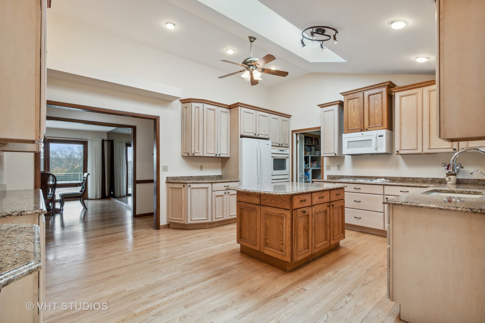 243 Butternut Road Barrington Hills, IL 60010 - Photo 8 of 56 a large kitchen with stainless steel appliances granite countertop a stove top oven a sink a dining table and chairs with wooden floor