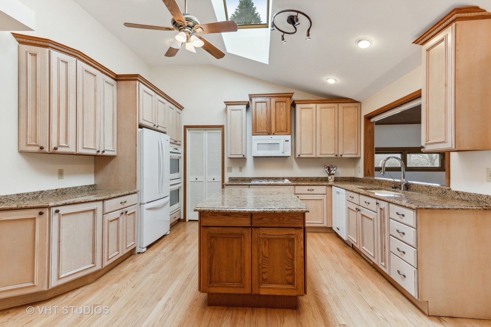 243 Butternut Road Barrington Hills, IL 60010 - Photo 9 of 56 a kitchen with kitchen island granite countertop wooden floors white cabinets and stainless steel appliances