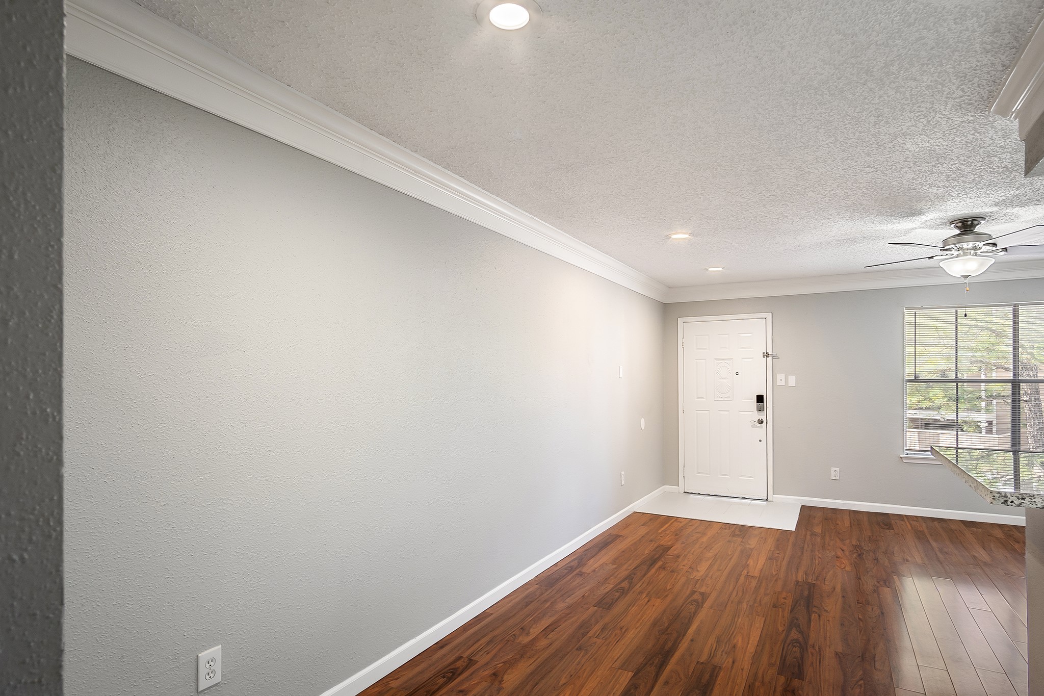 7402 Alabonson Road, Unit 510 Houston, TX 77088 - Photo 6 of 14 an empty room with wooden floor and windows