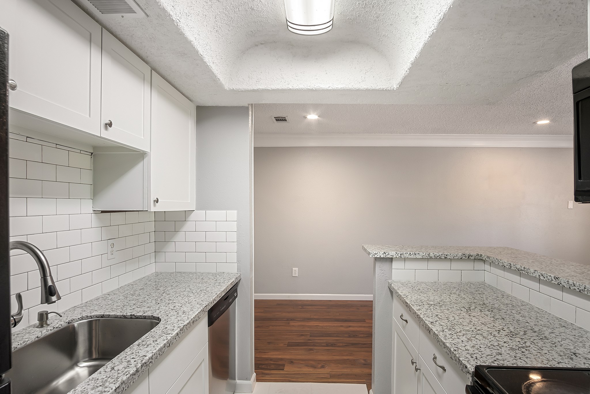 7402 Alabonson Road, Unit 510 Houston, TX 77088 - Photo 8 of 14 a kitchen with a granite countertop sink a stove and cabinets