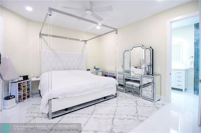 a bedroom with a bed a mirror and lamp