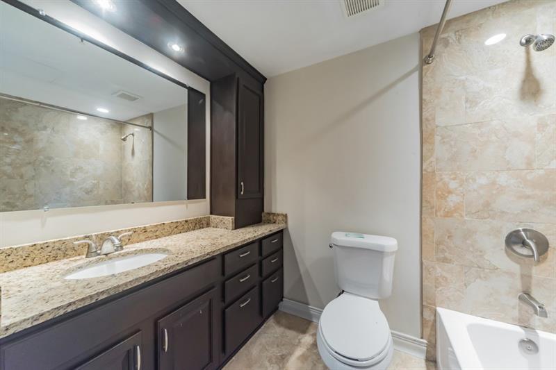 199 14th Street Northeast, Unit 705 Atlanta, GA 30309 - Photo 15 of 20 a bathroom with a granite countertop toilet sink and mirror