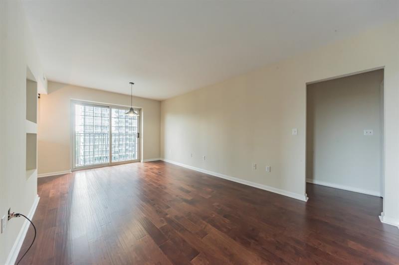 199 14th Street Northeast, Unit 705 Atlanta, GA 30309 - Photo 3 of 20 a view of an empty room with wooden floor and window