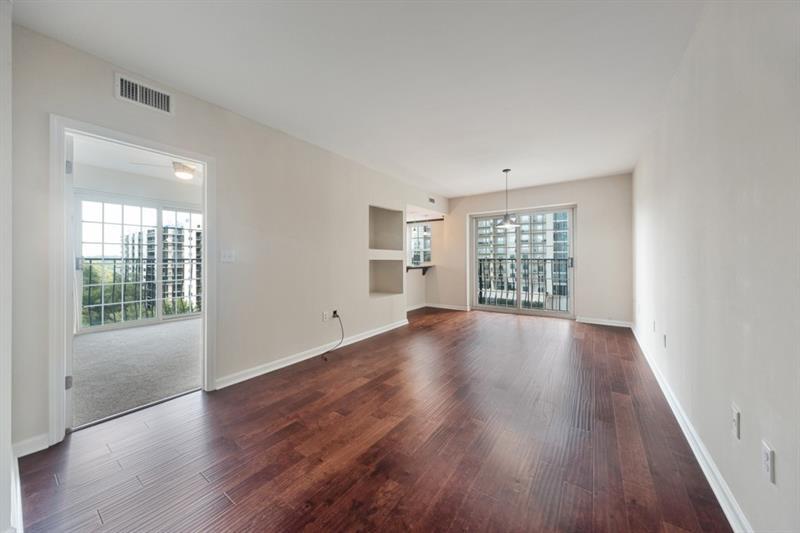 199 14th Street Northeast, Unit 705 Atlanta, GA 30309 - Photo 6 of 20 an empty room with wooden floor and windows