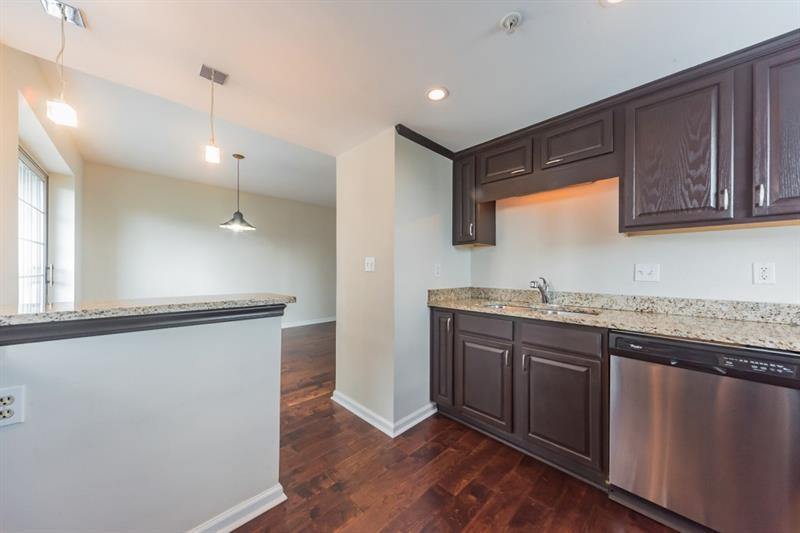 199 14th Street Northeast, Unit 705 Atlanta, GA 30309 - Photo 9 of 20 a kitchen with granite countertop a sink cabinets and wooden floor