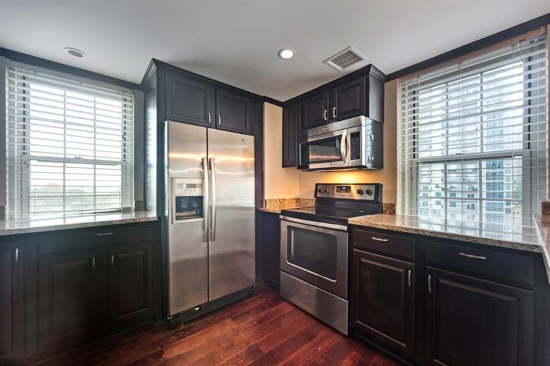 199 14th Street Northeast, Unit 705 Atlanta, GA 30309 - Photo 10 of 20 a kitchen with granite countertop a refrigerator and a sink