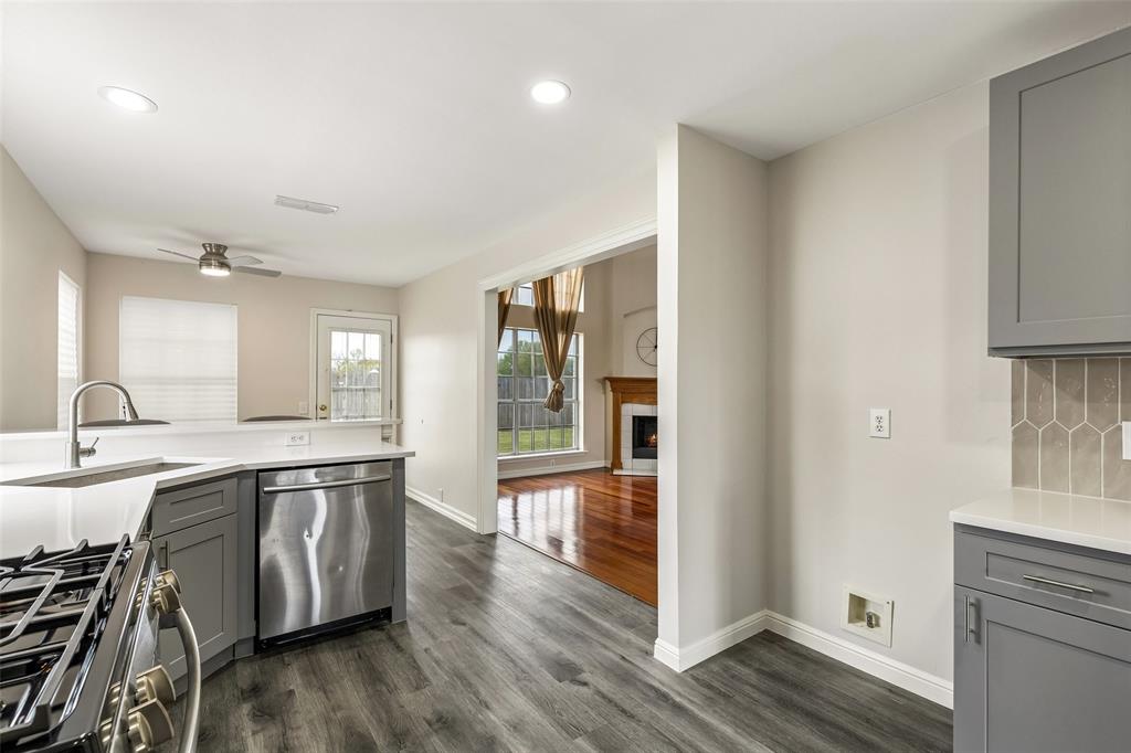 133 Hanover Street Grand Prairie, TX 75052 - Photo 11 of 31 a large kitchen with stainless steel appliances granite countertop a lot of counter space and wooden floor