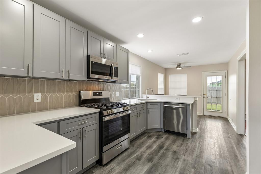 133 Hanover Street Grand Prairie, TX 75052 - Photo 12 of 31 a kitchen with a sink stove top oven and cabinets