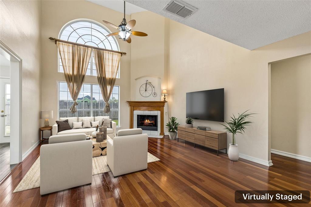 133 Hanover Street Grand Prairie, TX 75052 - Photo 3 of 31 a living room with furniture a flat screen tv and a fireplace